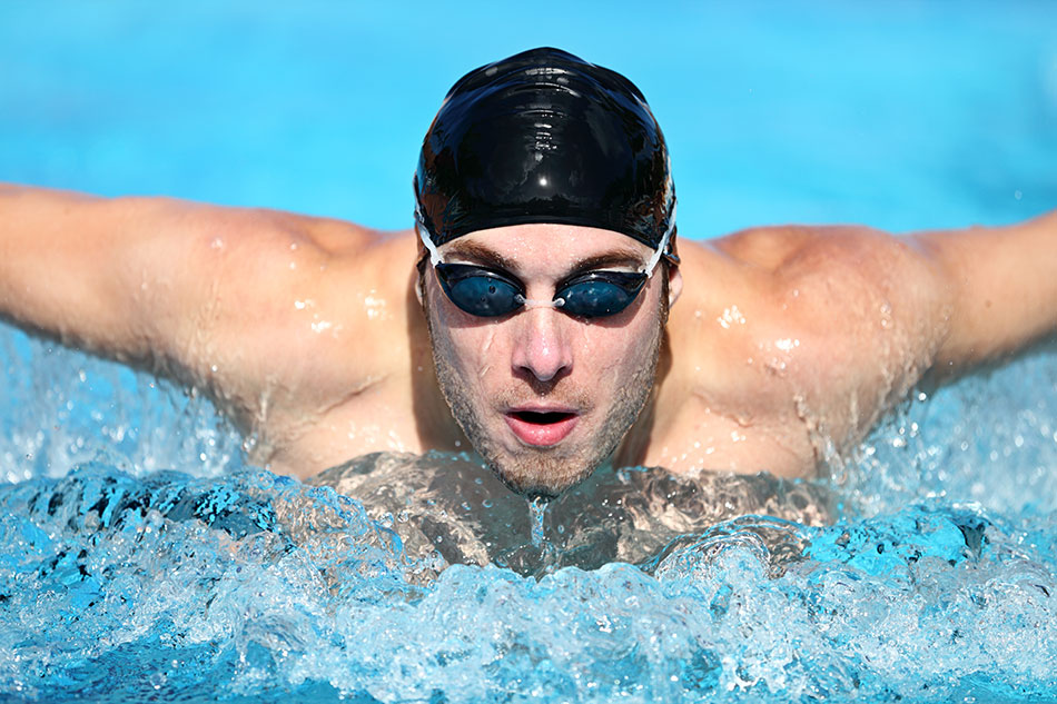 young man swimming with goggles