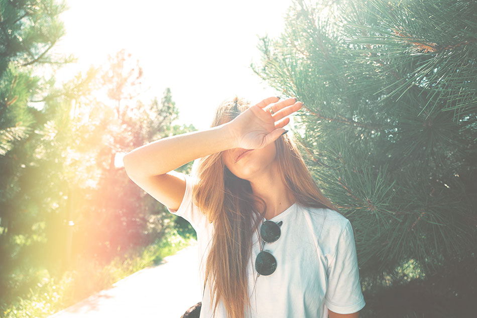 young woman shielding eyes from sunlight