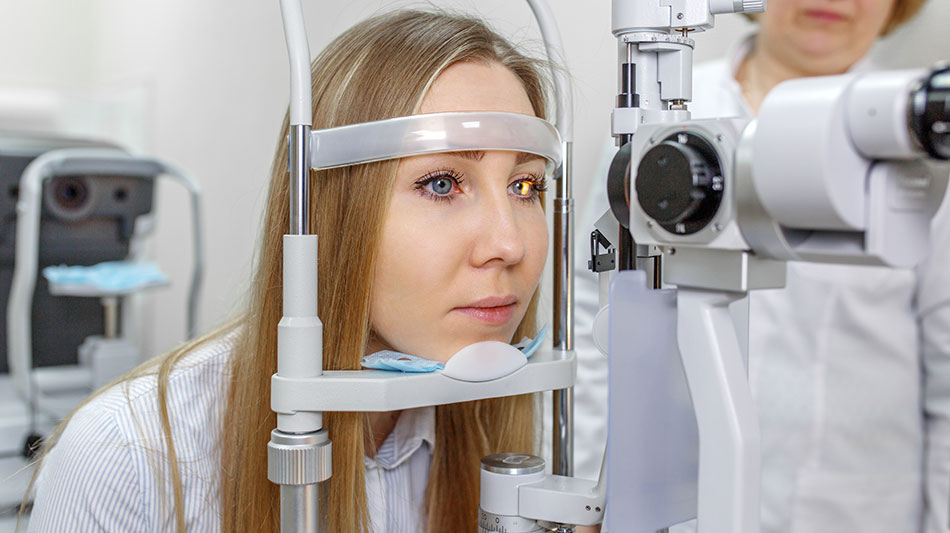 young woman on slit lamp during eye exam